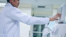   Doctor looking at a dialysis machine while in a care clinic or hospital