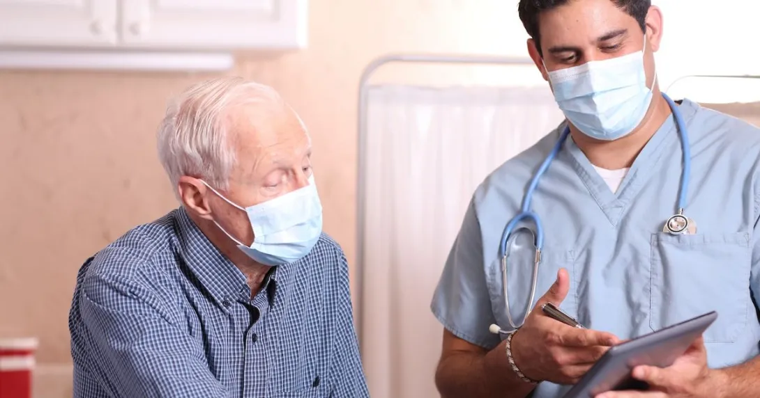 A medical professional with a tablet consults with patient A medical professional with a tablet consults with patient
